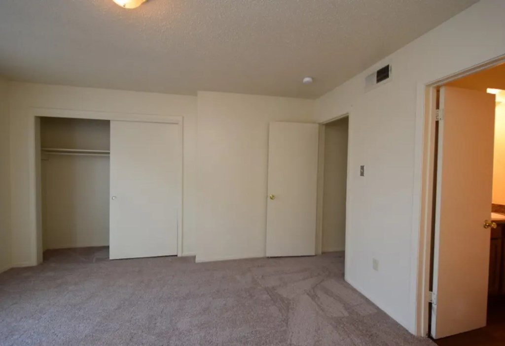 A room with a carpeted floor and white walls.